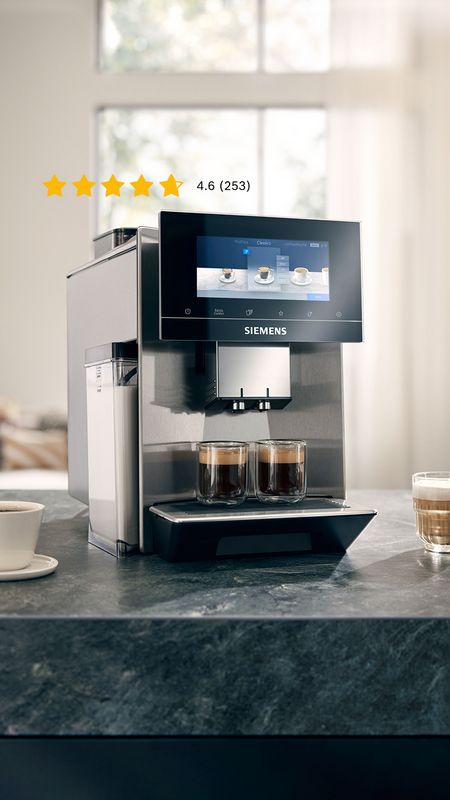 Ein Siemens Kaffeevollautomat steht neben verschiedenen Kaffeespezialitäten auf einer Küchenarbeitsplatte.