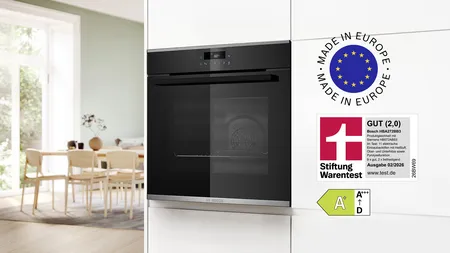 Der Bosch Einbau-Backofen in einer weißen Küchenfront mit unterschiedlichen Logos zu Testurteil und Herstellung.