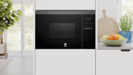 Microondas Balay empotrado negro con panel digital en cocina moderna junto a frutas