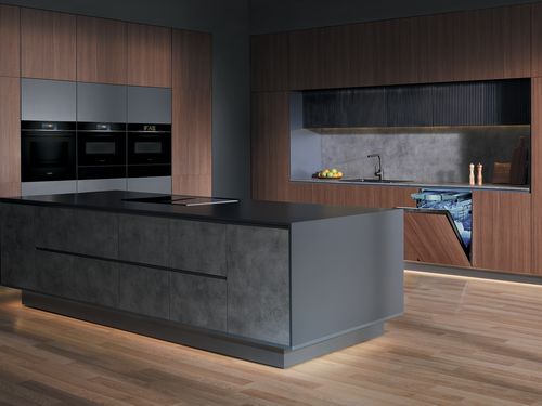 Nowoczesna kuchnia z wbudowaną lod&oacute;wką i piekarnikami ściennymi, z dużymi oknami wychodzącymi na stylowy kącik dzienny.