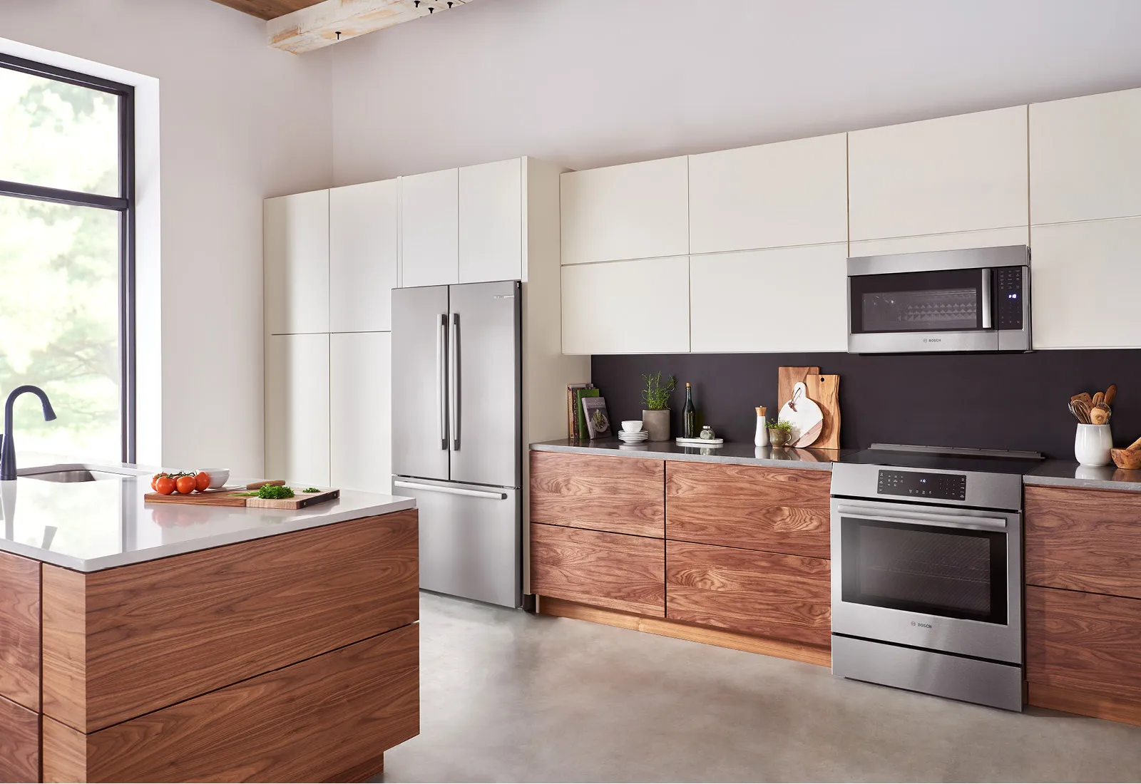 Modern kitchen with Bosch stainless steel appliances, wooden cabinets, and a central island.