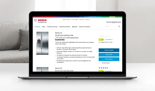 Laptop sitting on a table shows information about Bosch fridges.