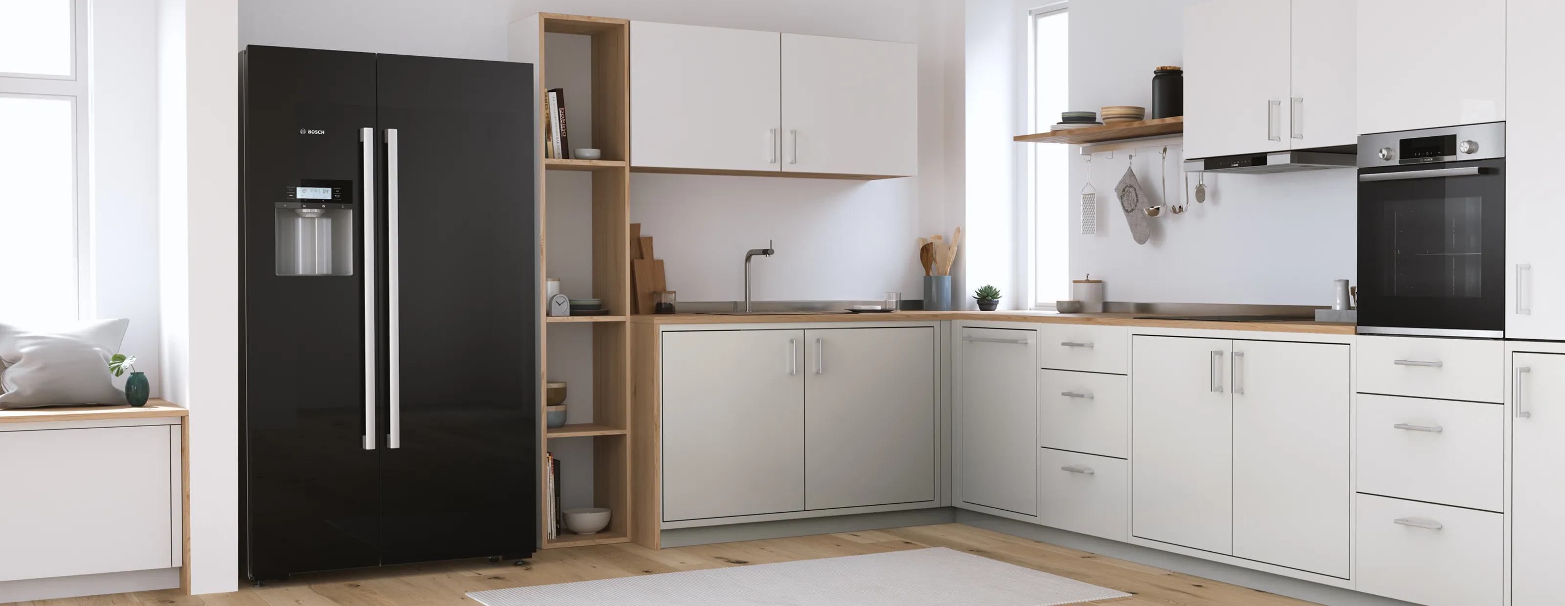 Black freestanding Bosch fridge with two large doors in a modern kitchen flooded with light.