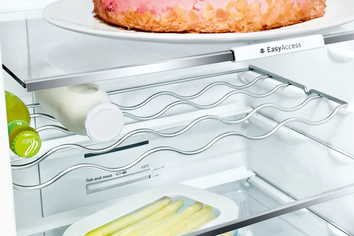 A beverage rack with bottles of milk and juice in a Bosch fridge.