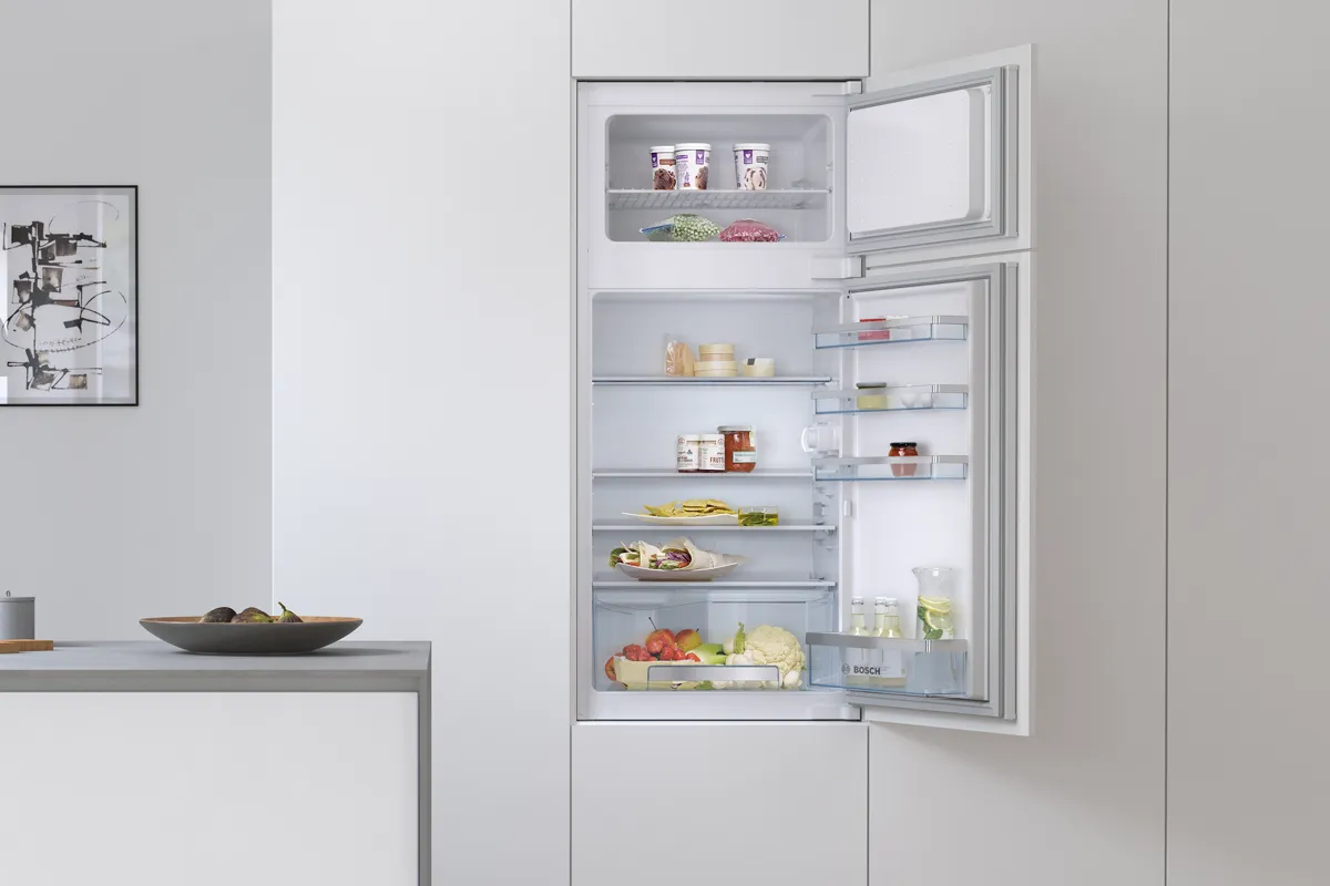 A 60-cm built-in Bosch fridge with open door to show food and drinks inside.