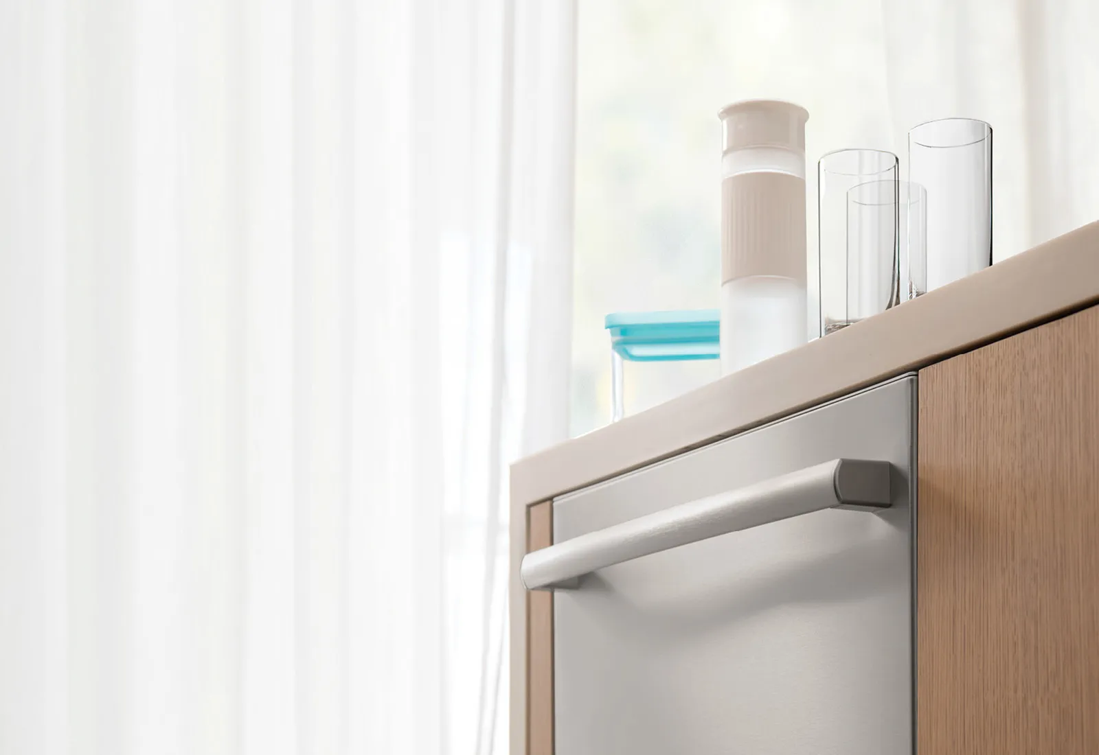 Minimalist kitchen interior with Bosch dishwasher, open cabinet, glassware, and natural light from window.