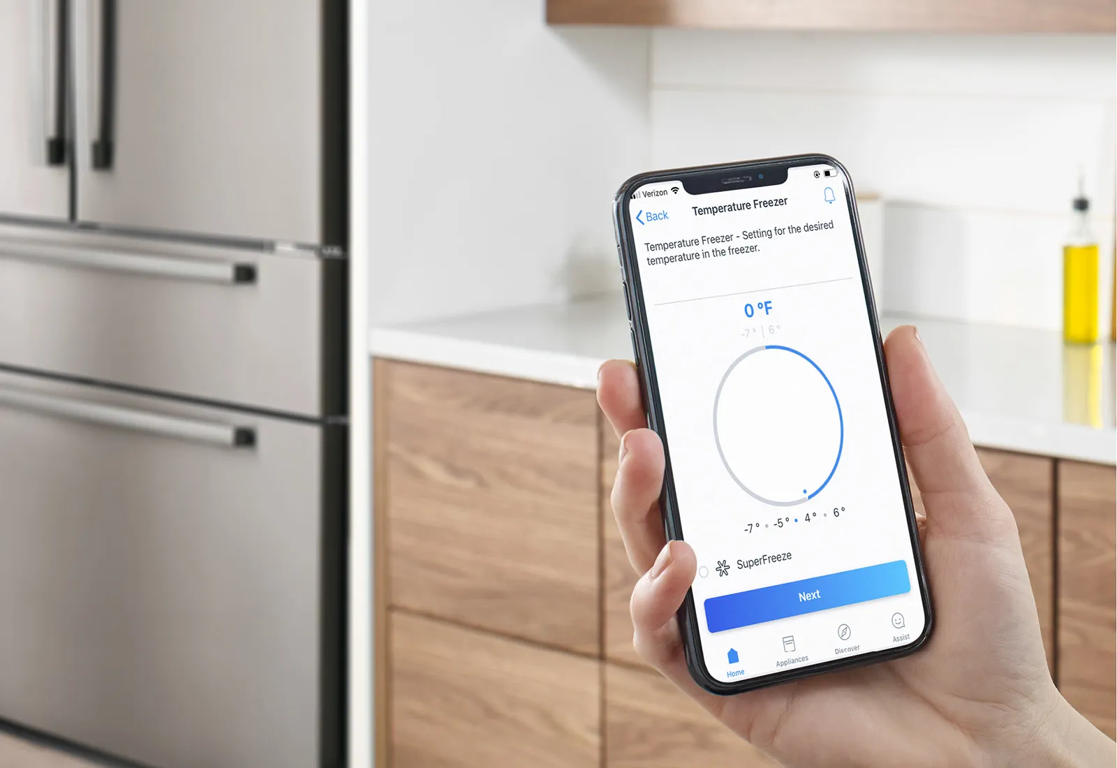 Smartphone displaying temperature reading app in Bosch kitchen setting with refrigerator.