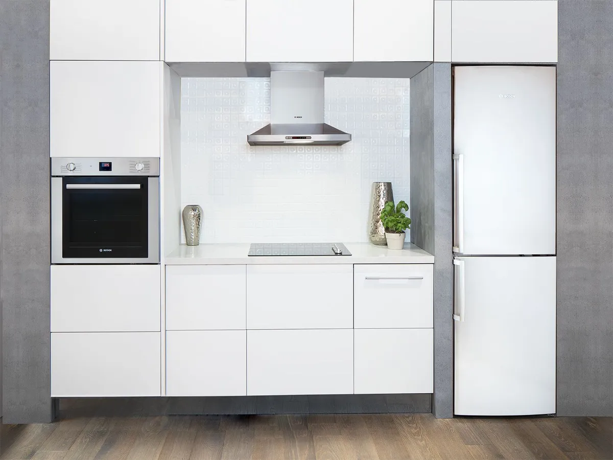 Modern white kitchen with Bosch appliances, cabinets, and countertop.