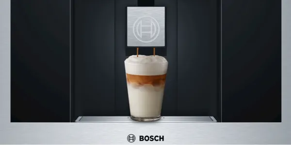 Bosch coffee machine dispensing a layered coffee drink with foam and branding.