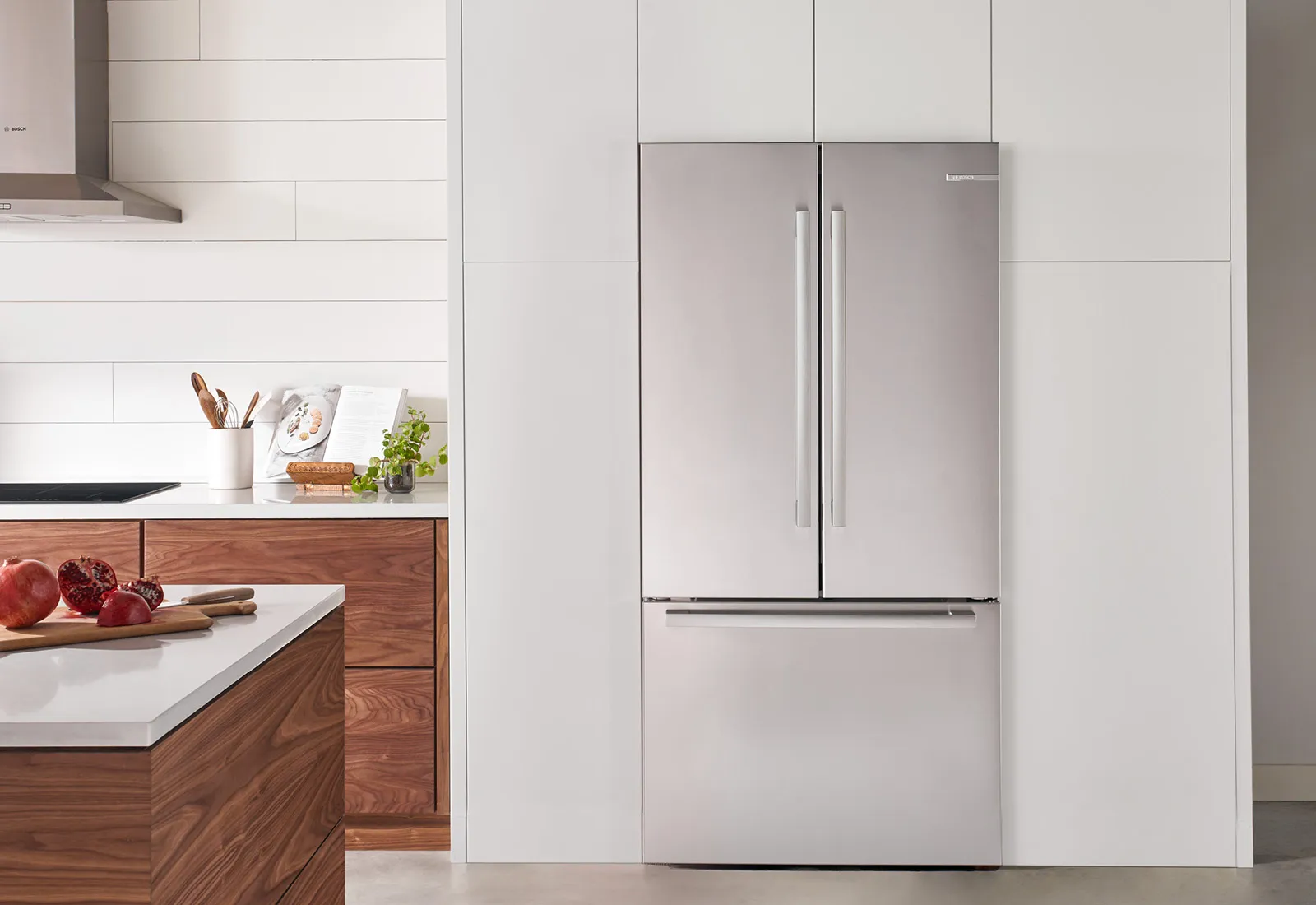 Modern Bosch stainless steel refrigerator with French double doors in a stylish kitchen setting.