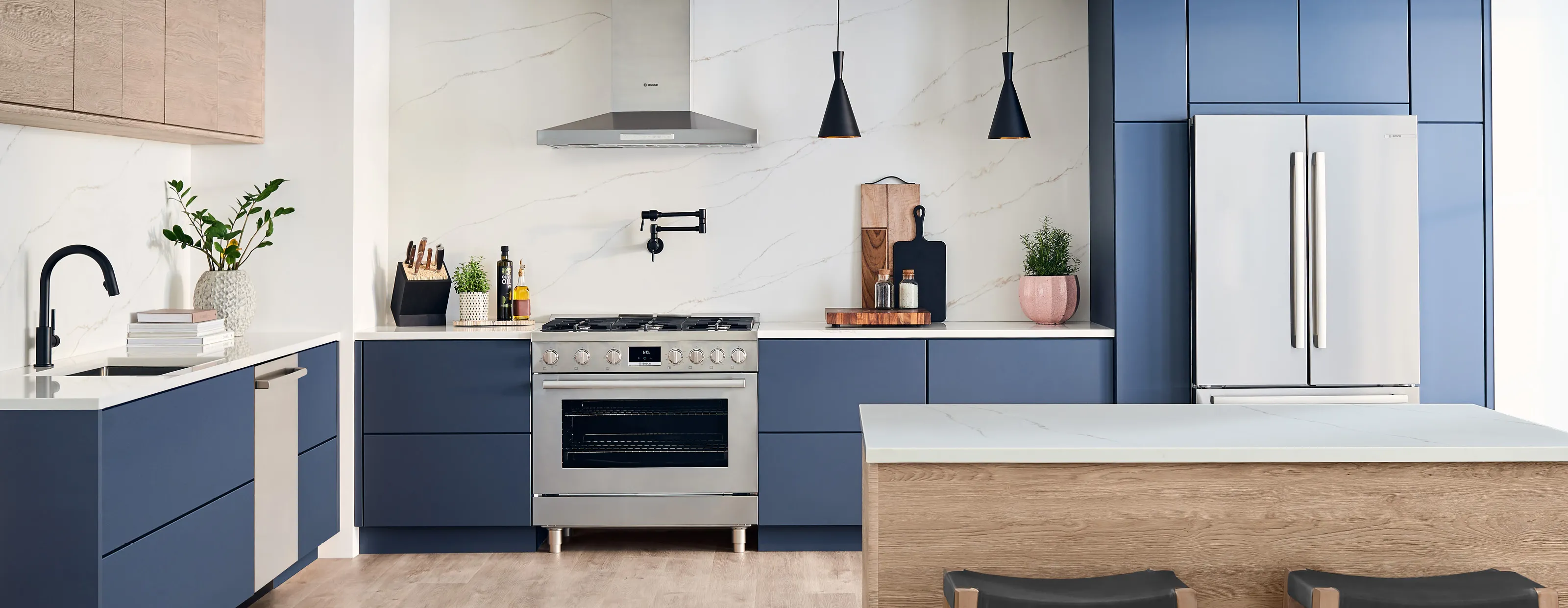 Modern kitchen with Bosch stainless steel appliances, blue cabinets, and decorative elements.