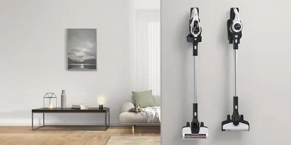 Soggiorno minimalista con arte della parete, mobili e due aspirapolvere verticali.