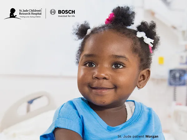 Child in a blue shirt smiling indoors, with logos of St. Jude and Bosch at the top.