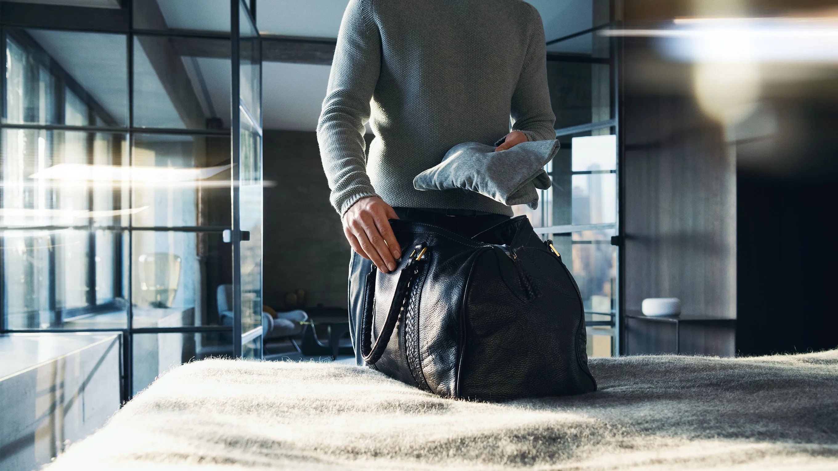 Person sitting on floor in office, laptop and bag nearby, looking thoughtful.