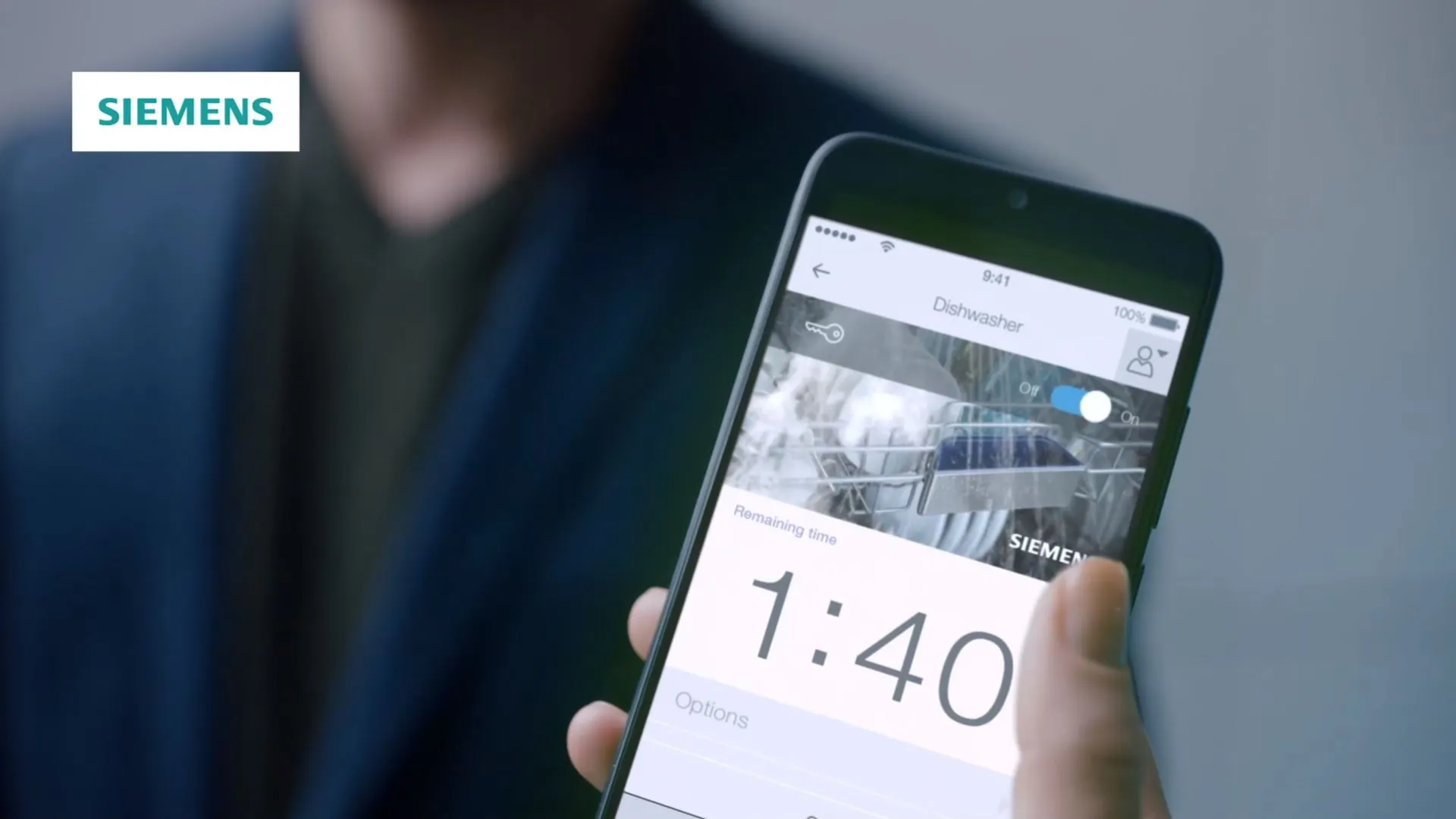 L'immagine mostra una persona che tiene uno smartphone che visualizza il logo Siemens e l'ora 1:40.
