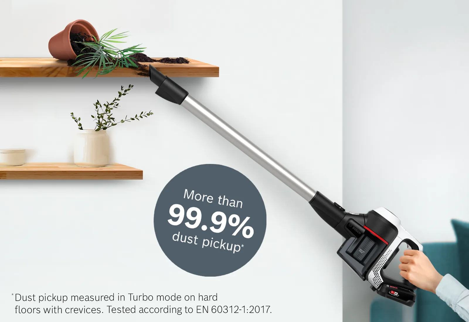 Persoană care folosește un aspirator Unlimited 6 pentru a curăța rafturi pe care se află ghivece cu plante