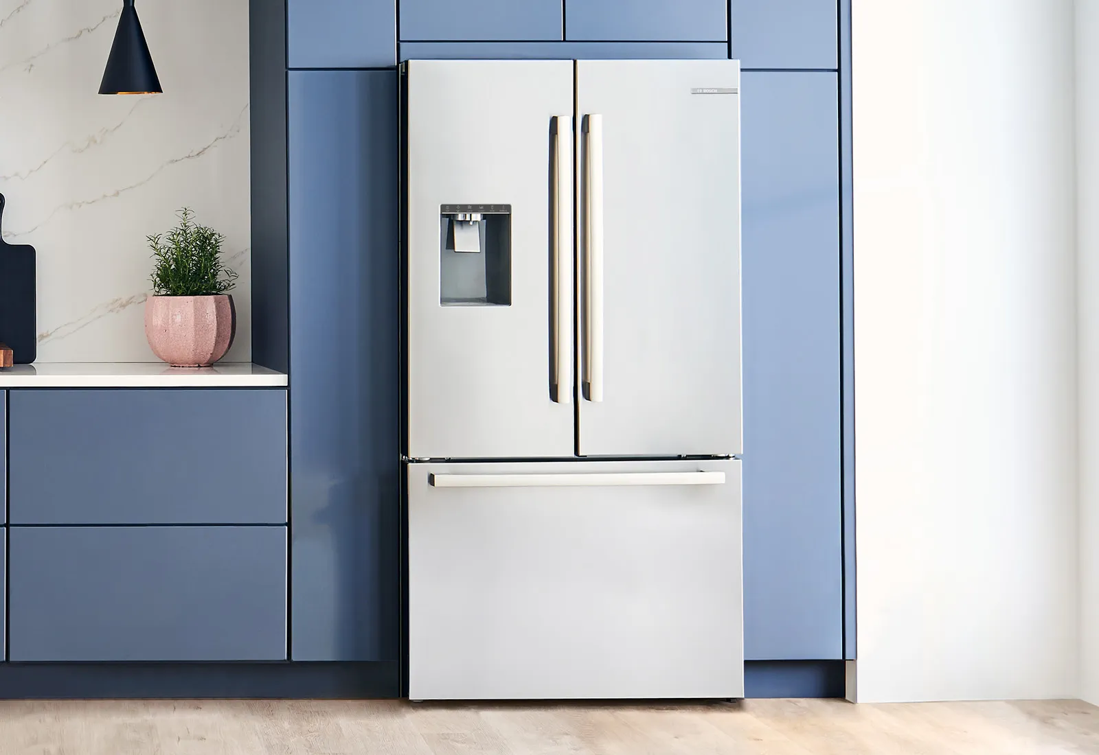 Bosch Stainless steel French door refrigerator with water dispenser, set in a modern kitchen.