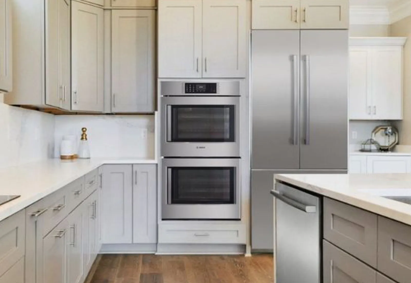 Bosch SideOpening Door Double Wall Oven in Stainless steel inside a modern kitchen next to a Bosch refrigerator
