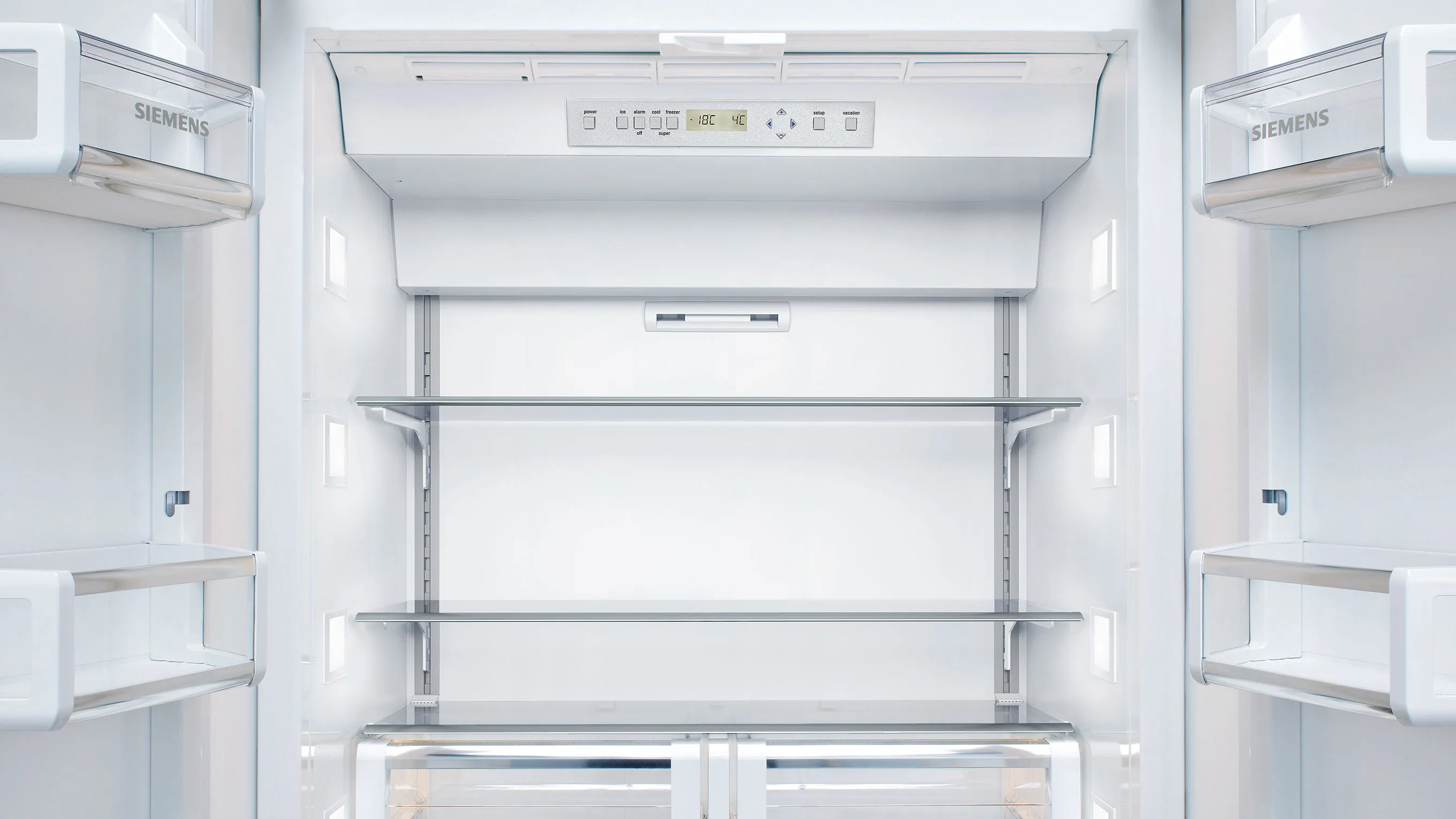 Empty refrigerator interior with shelves, lighting, and Siemens brand name visible.