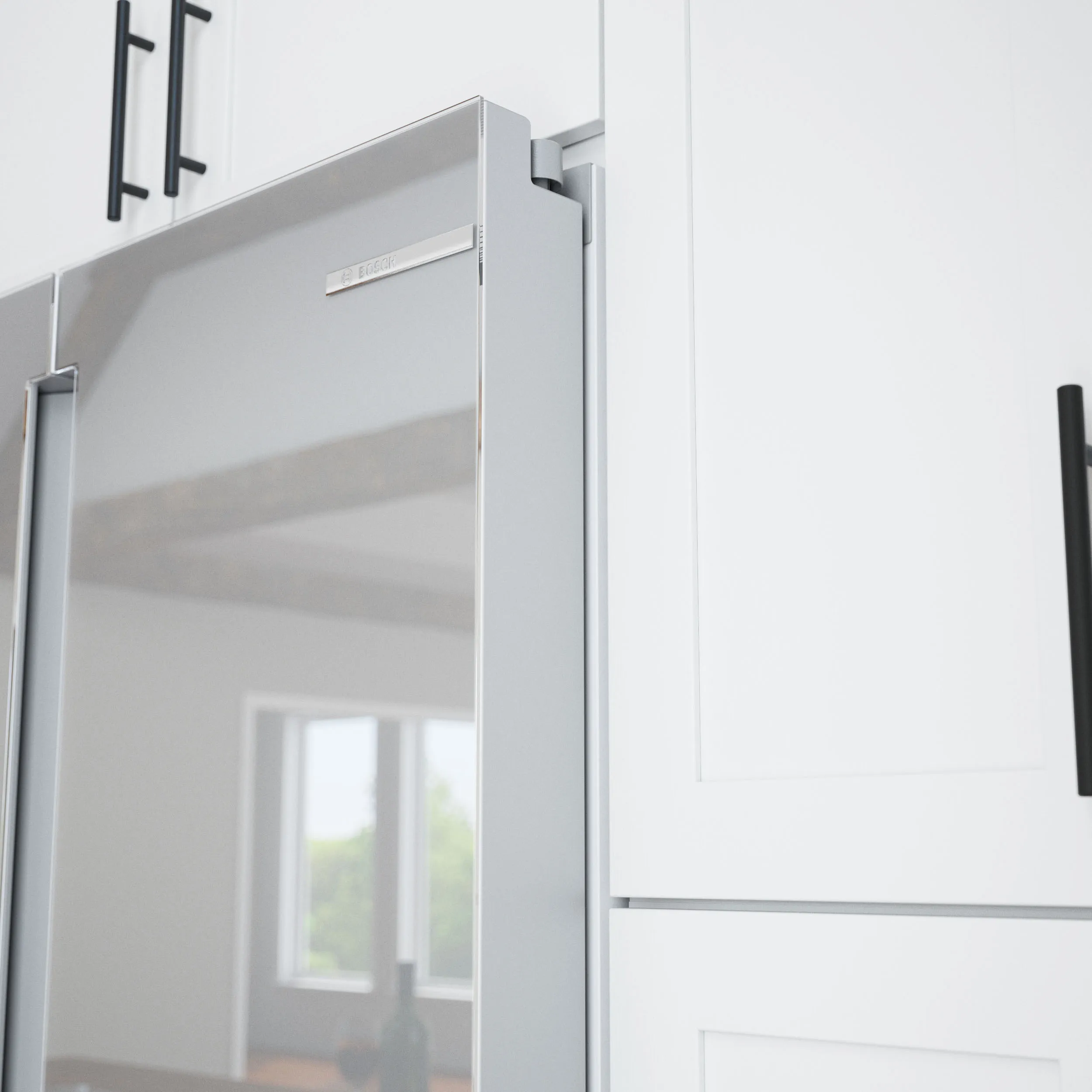 Bosch 24 inch Stainless steel refrigerator door integrated into white kitchen cabinetry design.