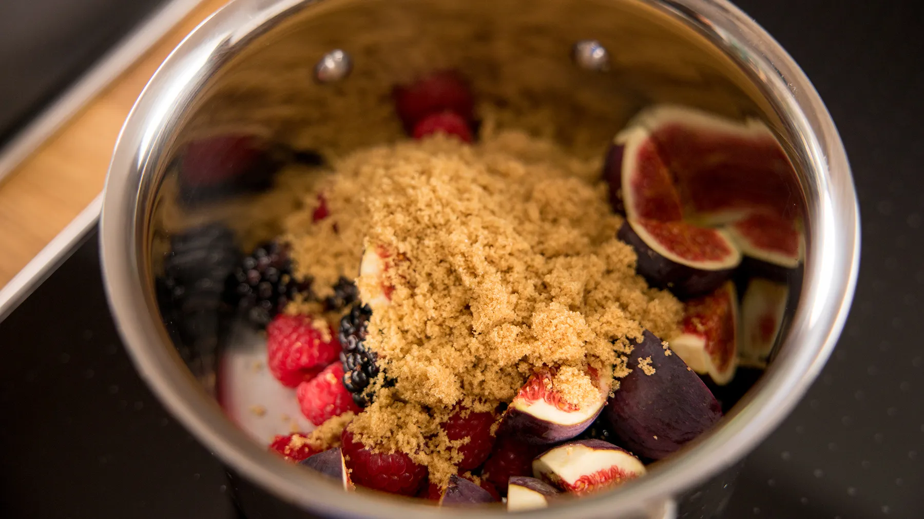Berry compote with sugar in pan