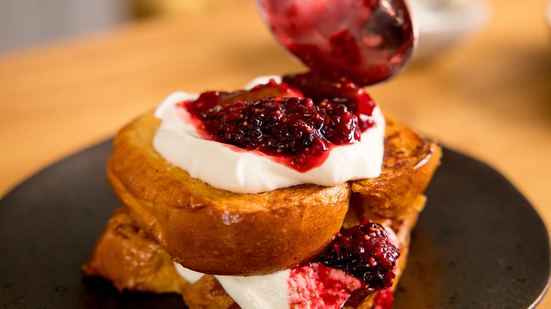 Pouring berry compote over French toast