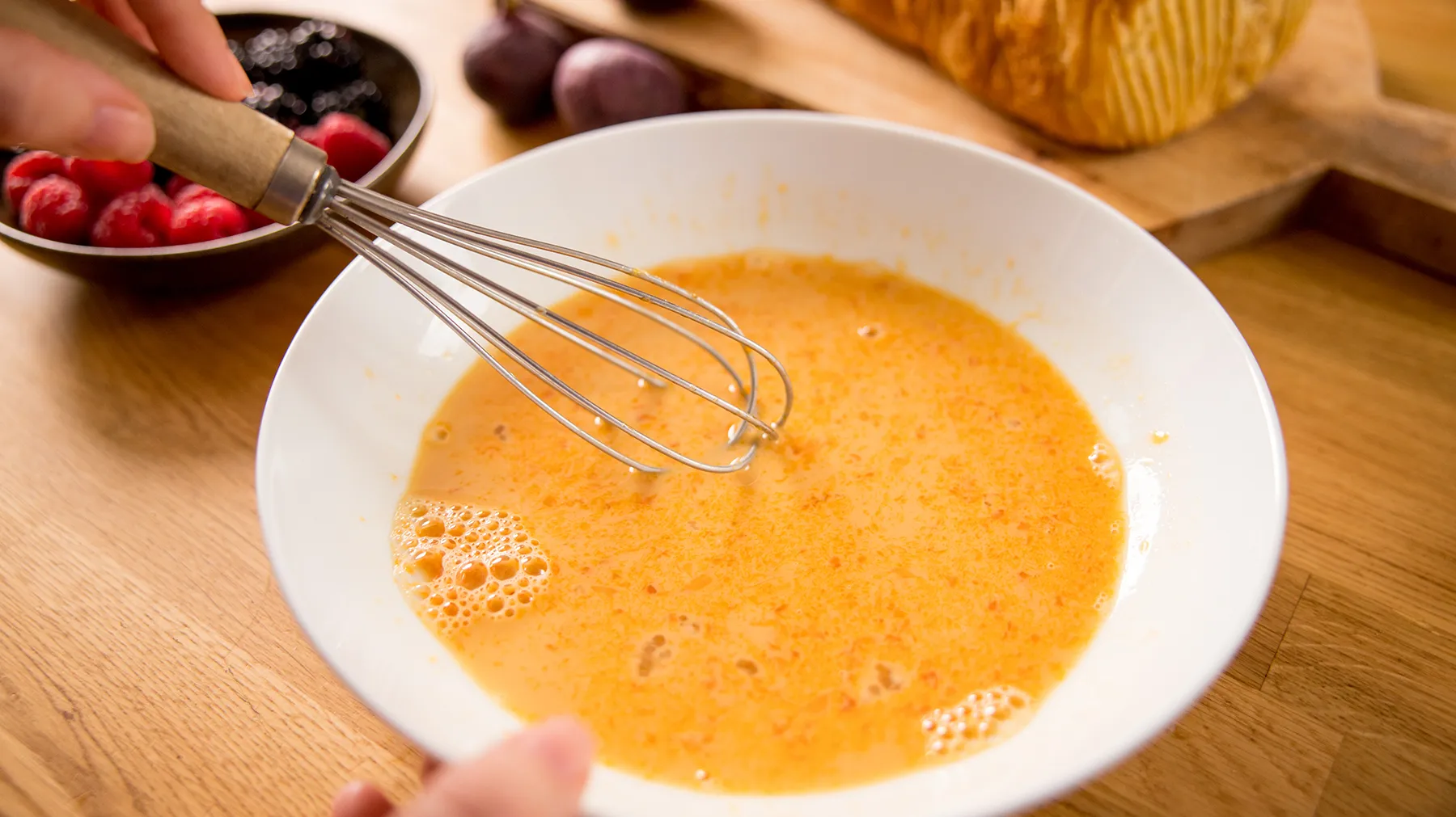 Hand whisking eggs in a bowl
