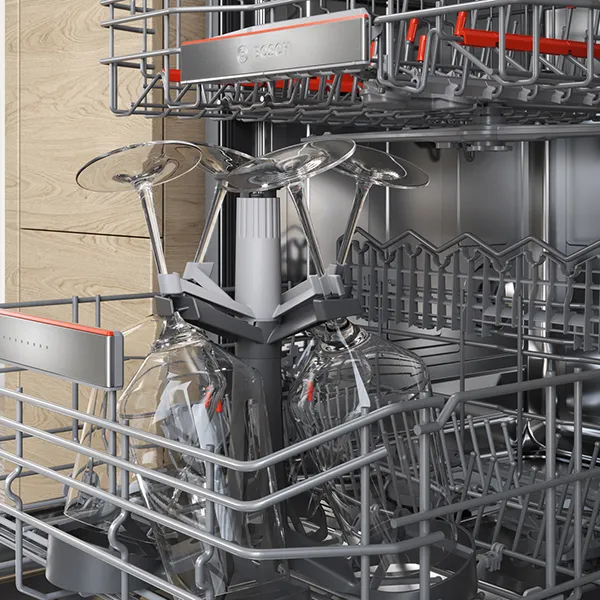 Open dishwasher with wine glasses inside.