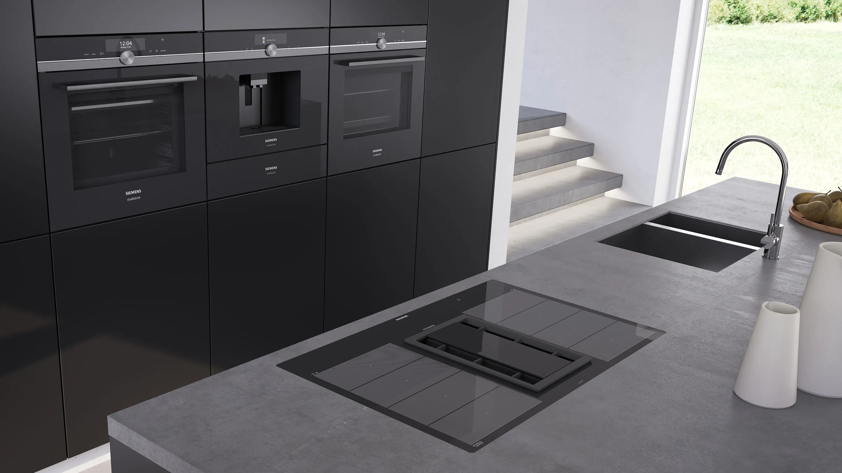 Modern kitchen with black cabinets, built-in appliances, and a gray countertop with a sink.