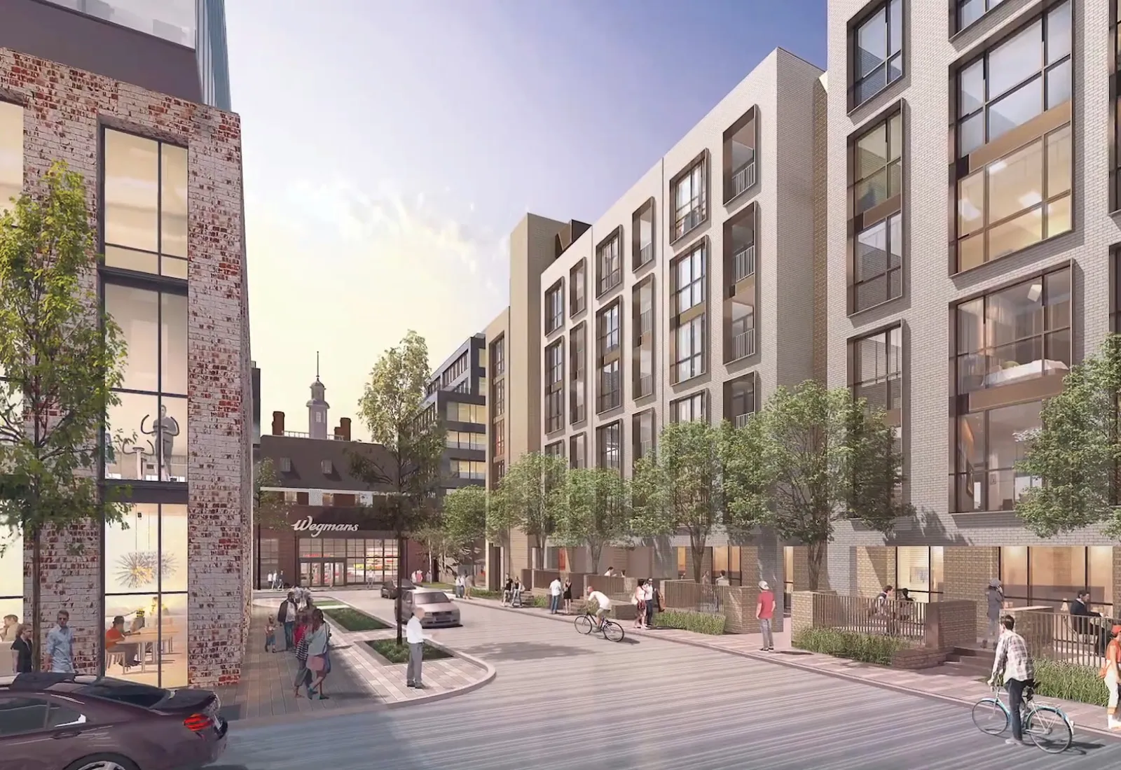 Modern urban buildings with large windows and trees lining a pedestrian-friendly street.