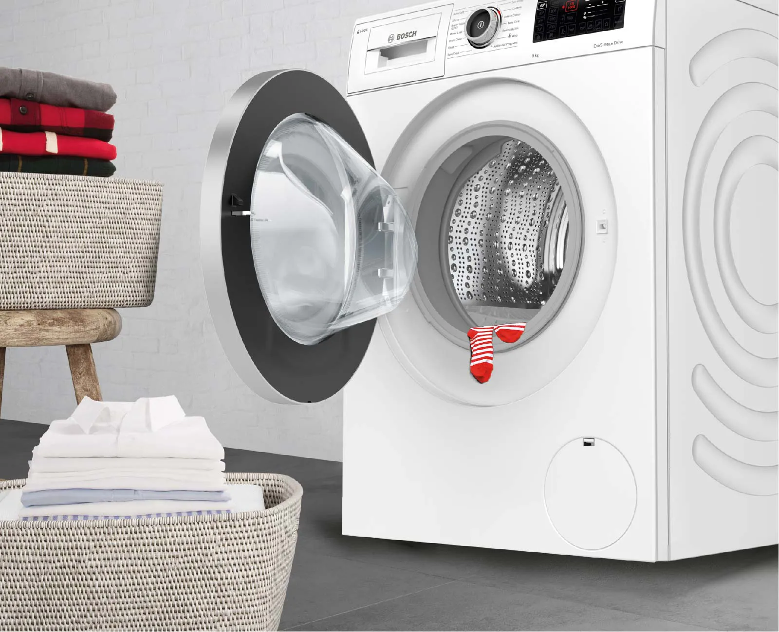 White front‑loading washing machine with the door open, showing a red sock stuck between the drum and door seal.