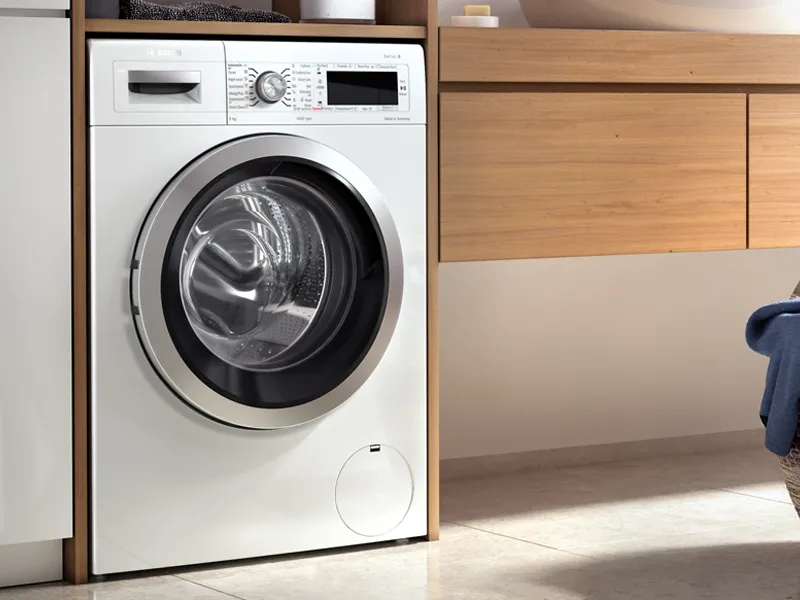 Bosch standard size front load washer in a modern white bathroom