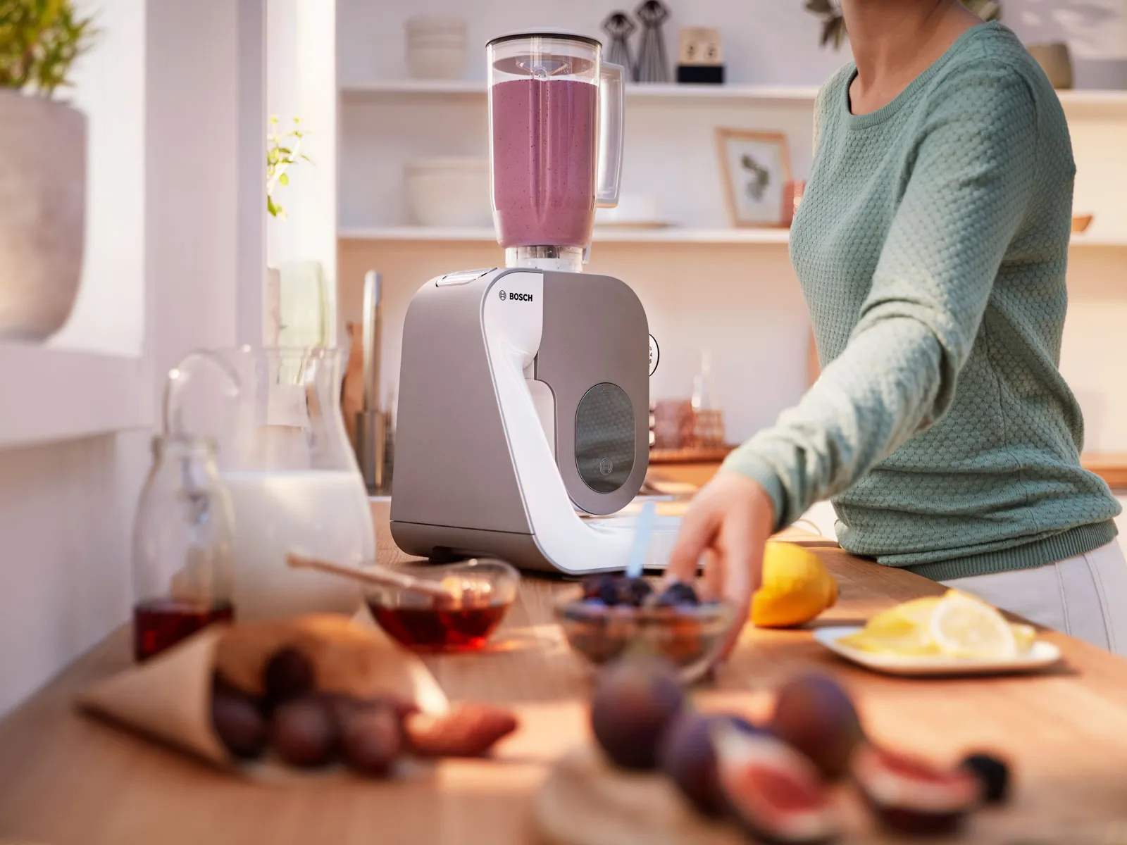 Robot bucătărie MUM5 echipat cu blender care contine un smoothie, pe un blat de bucătărie