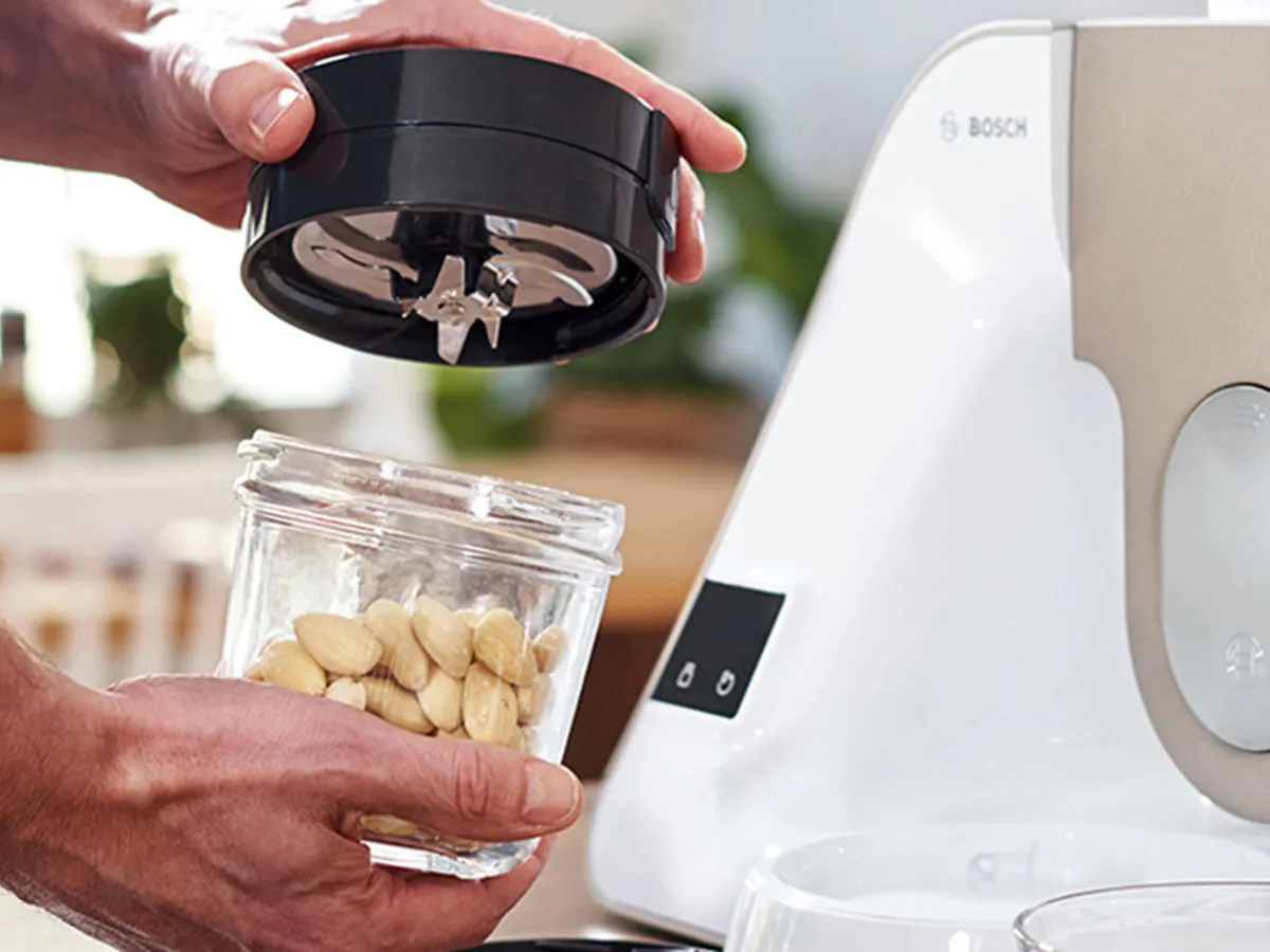 În prim-plan accesoriu TastyMoments cu ingrediente, in plan secundar robot de bucătărie Bosch MUM5