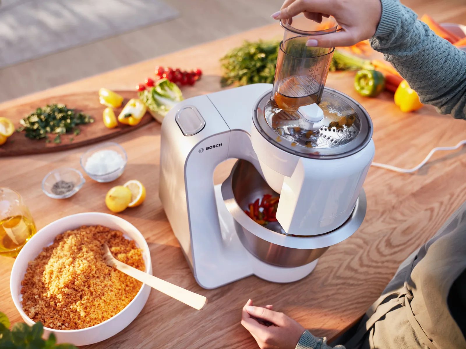 Robot de bucătărie MUM5 achipat cu accesoriu VeggieLove care procesează diverse ingrediente