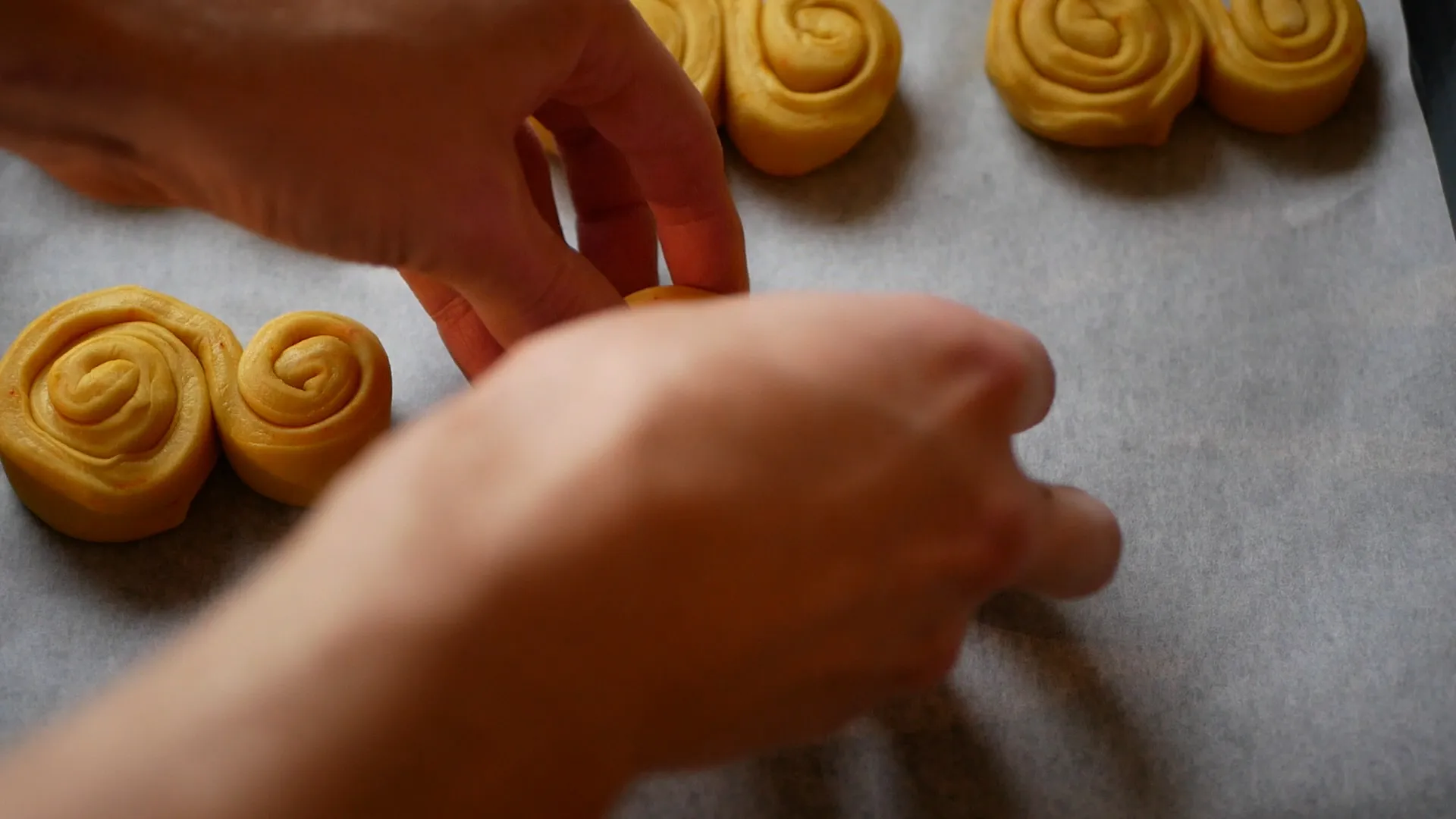 Steg 6 av att baka klassiska svenska saffransbullar, med gyllengräddade bullar på en plåt i Neff-ugn