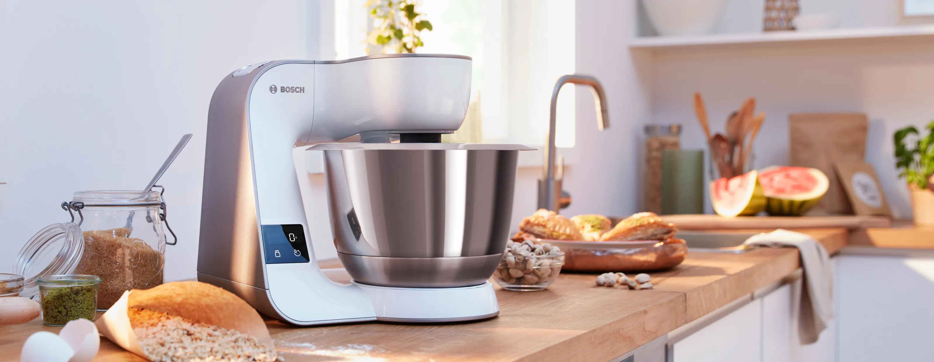 Contor de bucătărie cu mixer alimentar, produse coapte și produse proaspete.