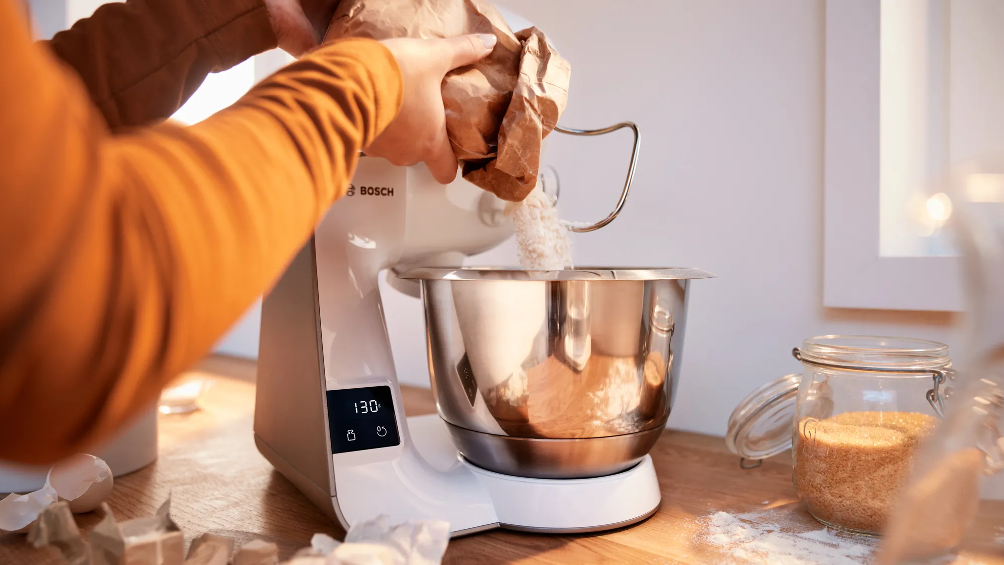Persoana care utilizează un mixer stand pentru a pregăti aluatul sau aluatul într-un cadru de bucătărie.