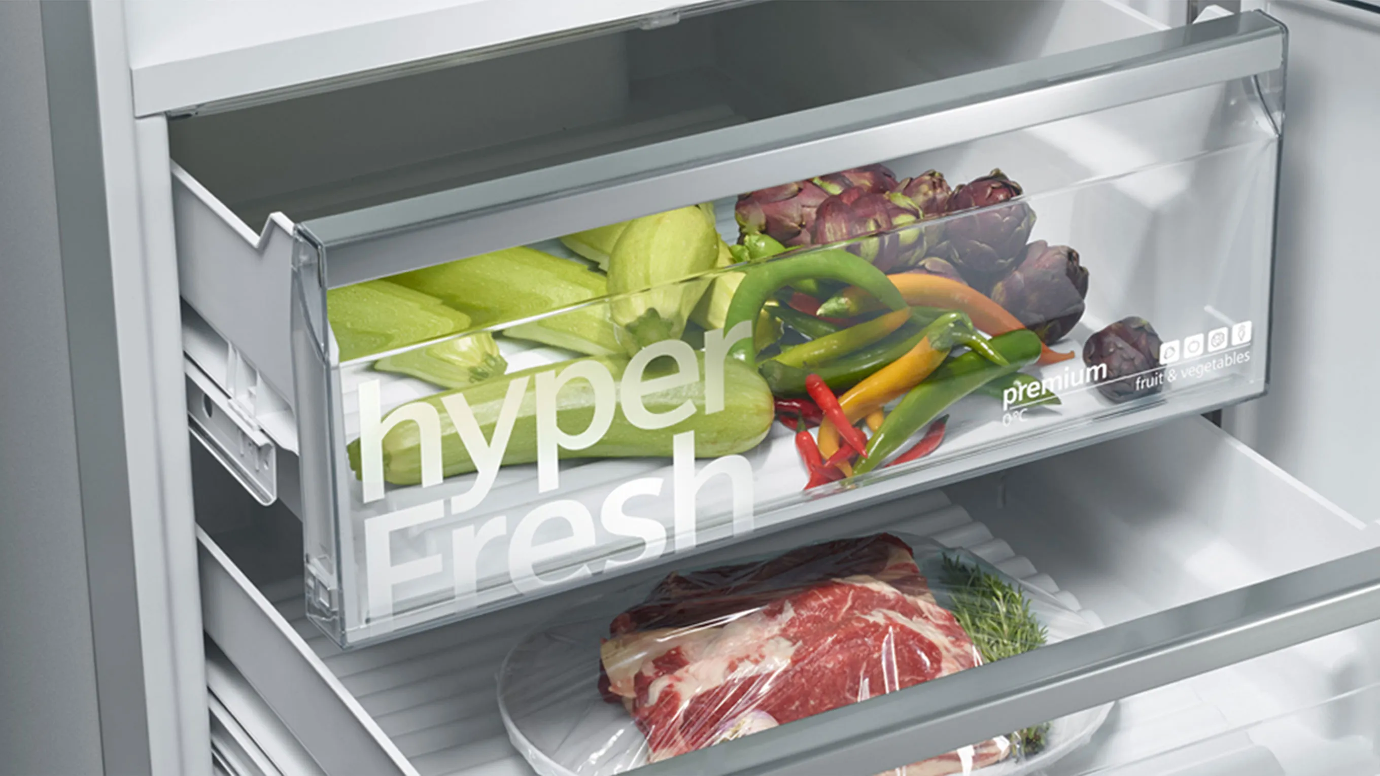 Refrigerator interior with fresh produce and meat, organized in labeled drawers.