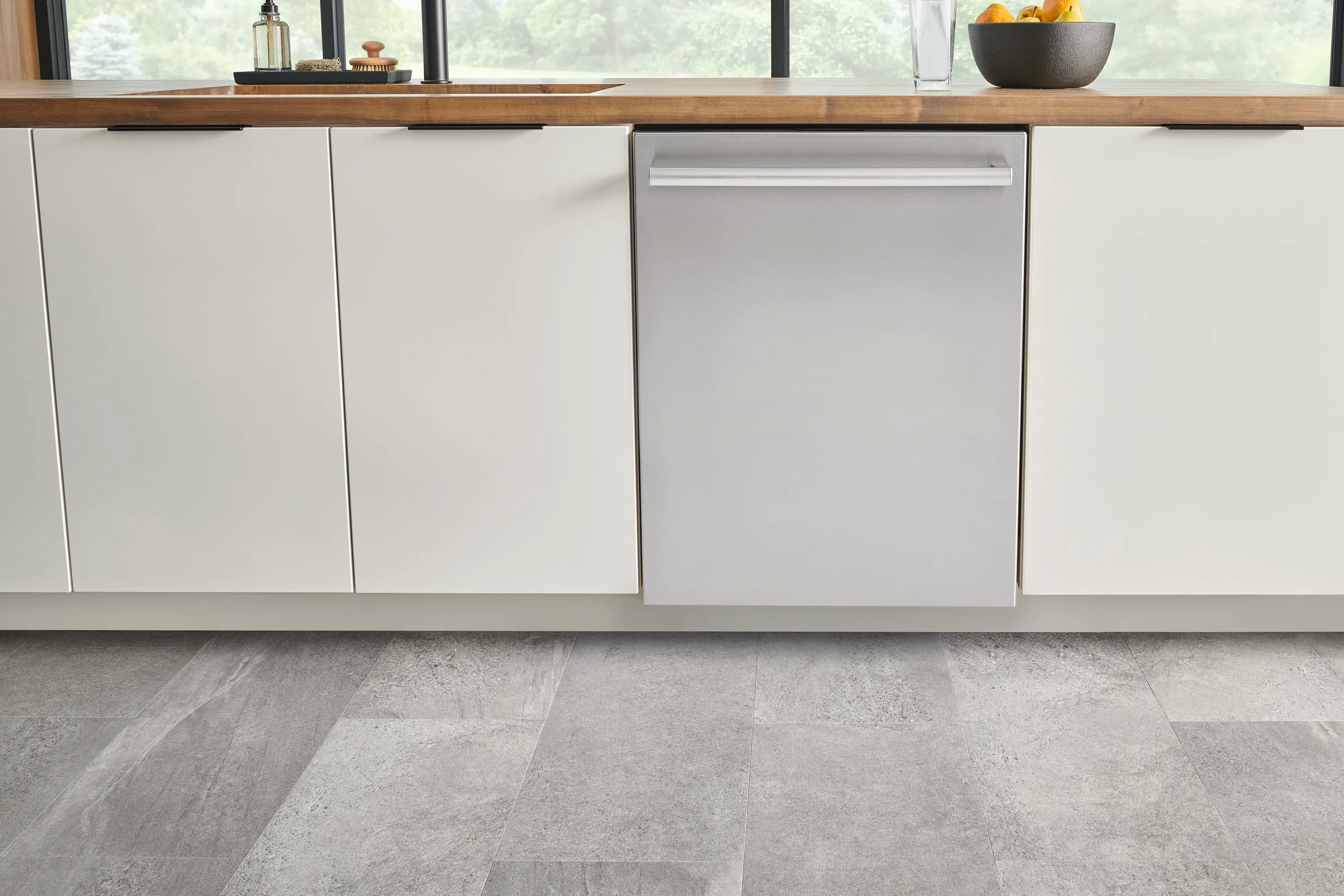 Modern kitchen with a Bosch built-in stainless steel dishwasher under a wooden countertop.