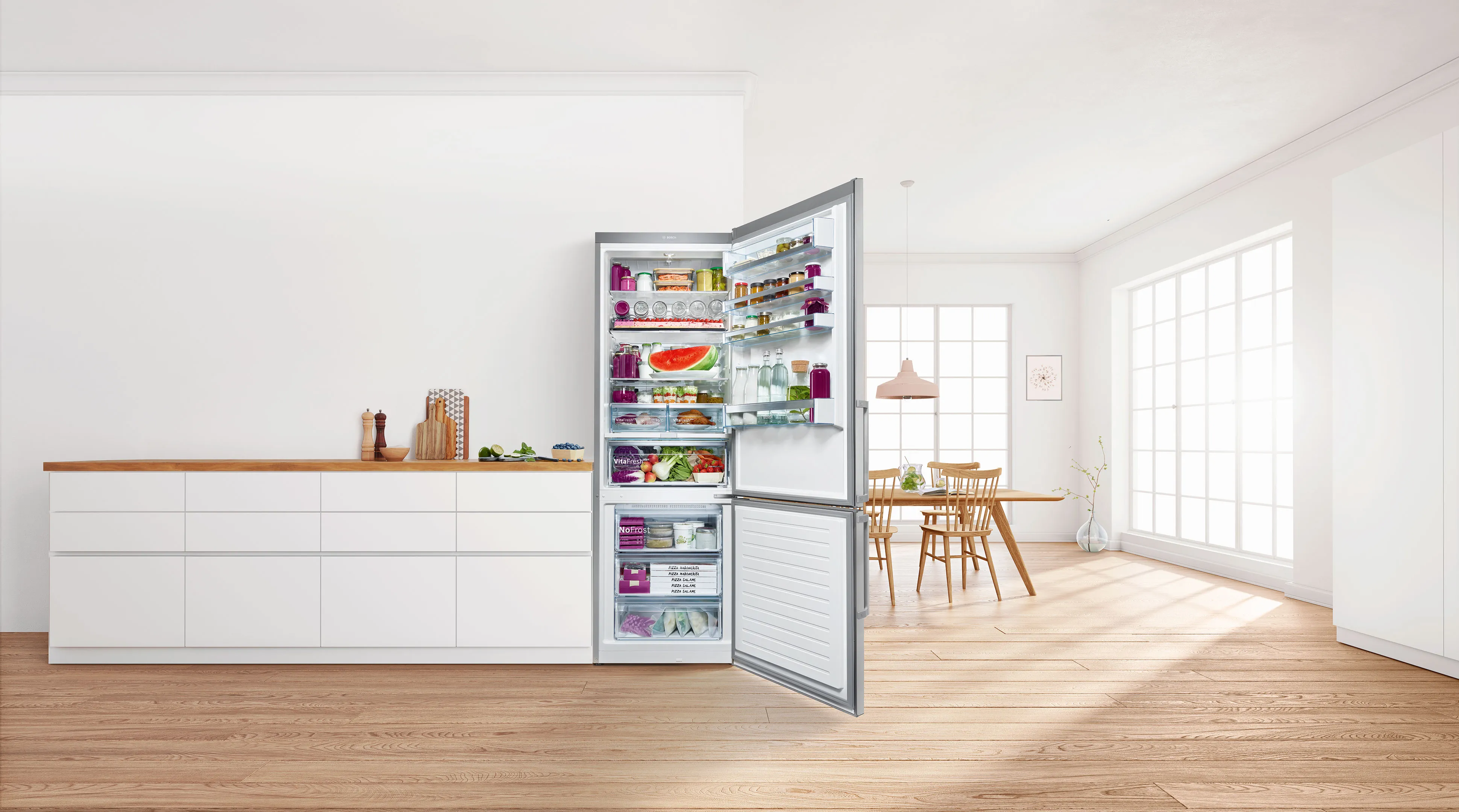 Luminosa, cucina moderna con frigorifero aperto che mostra vari elementi alimentari.