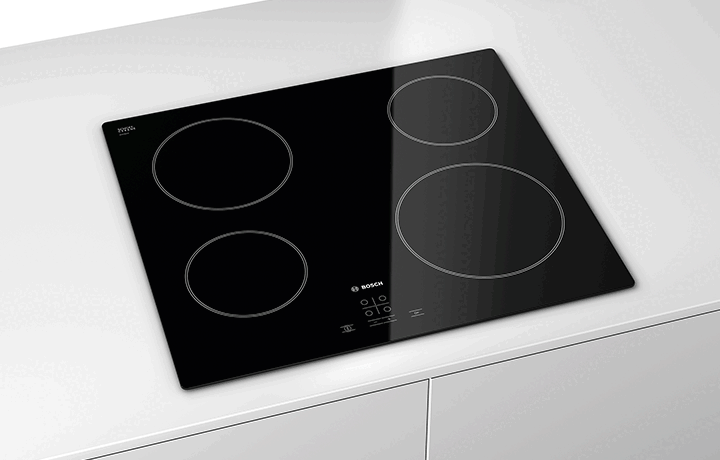 Black glass electric cooktop with four circular cooking zones.