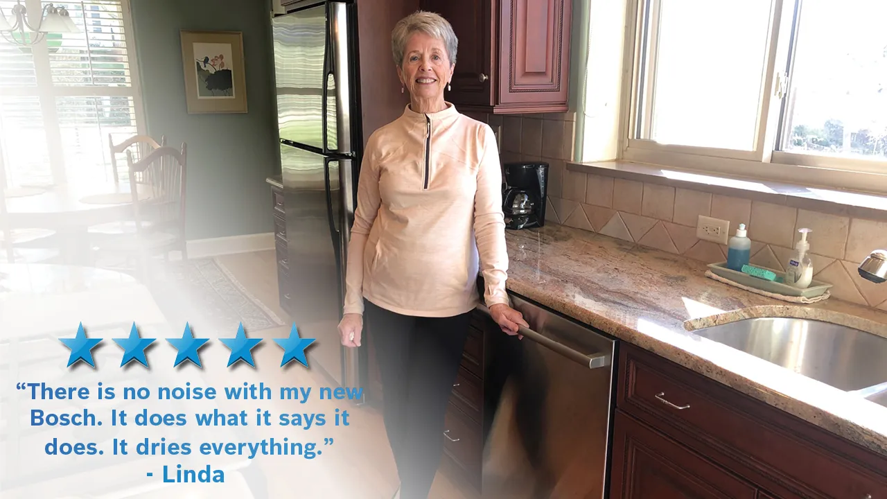 Elderly woman in kitchen, smiling and giving positive review of Bosch appliance.