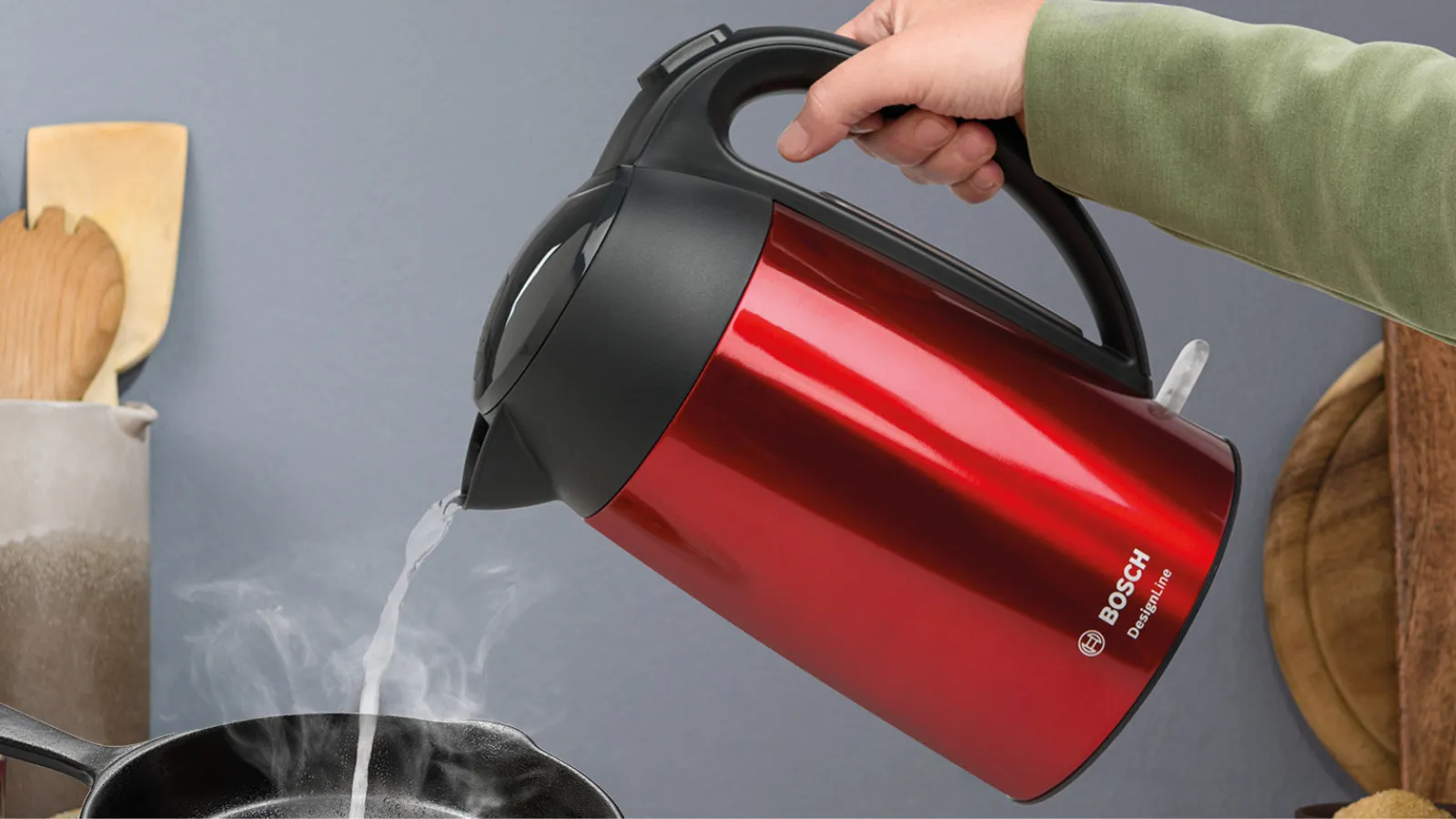Person pouring boiling water from kettle