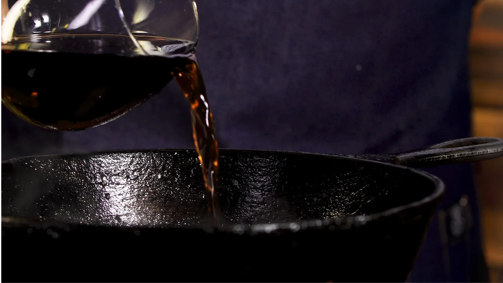 Pouring cola into pan to clean