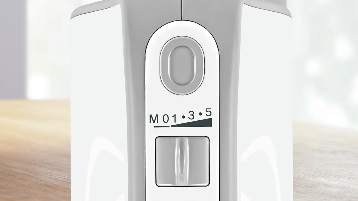 A top view of a 5-speed hand mixer's handle with focus on the speed settings.