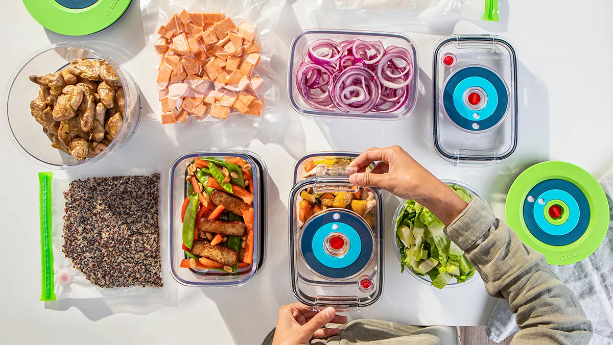 Plusieurs boîtes de conservation sous vide remplies d'aliments différents qui seront conditionnés sous vide pour être conservés.