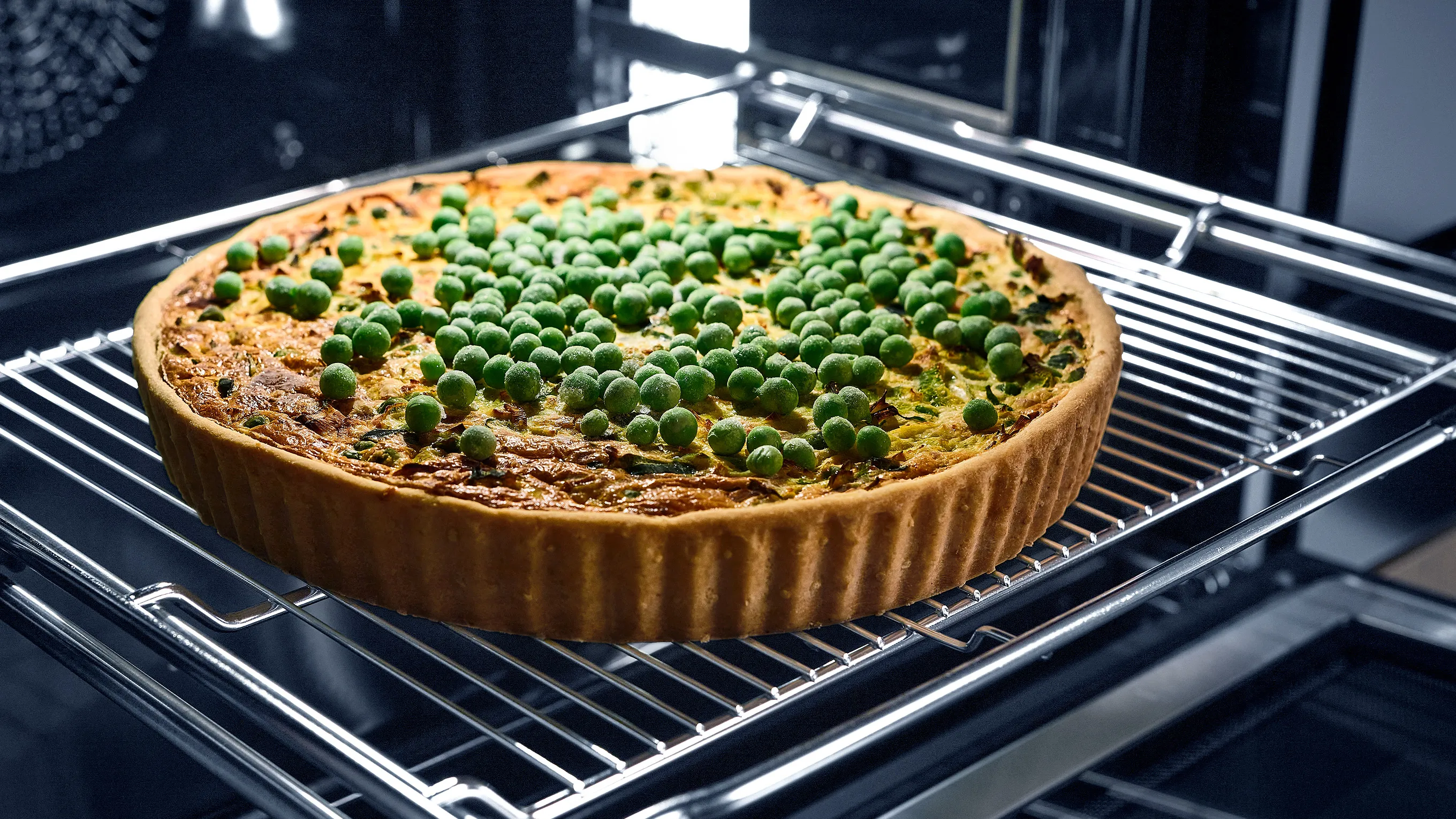 Baked tart with green peas and crumble topping in oven.