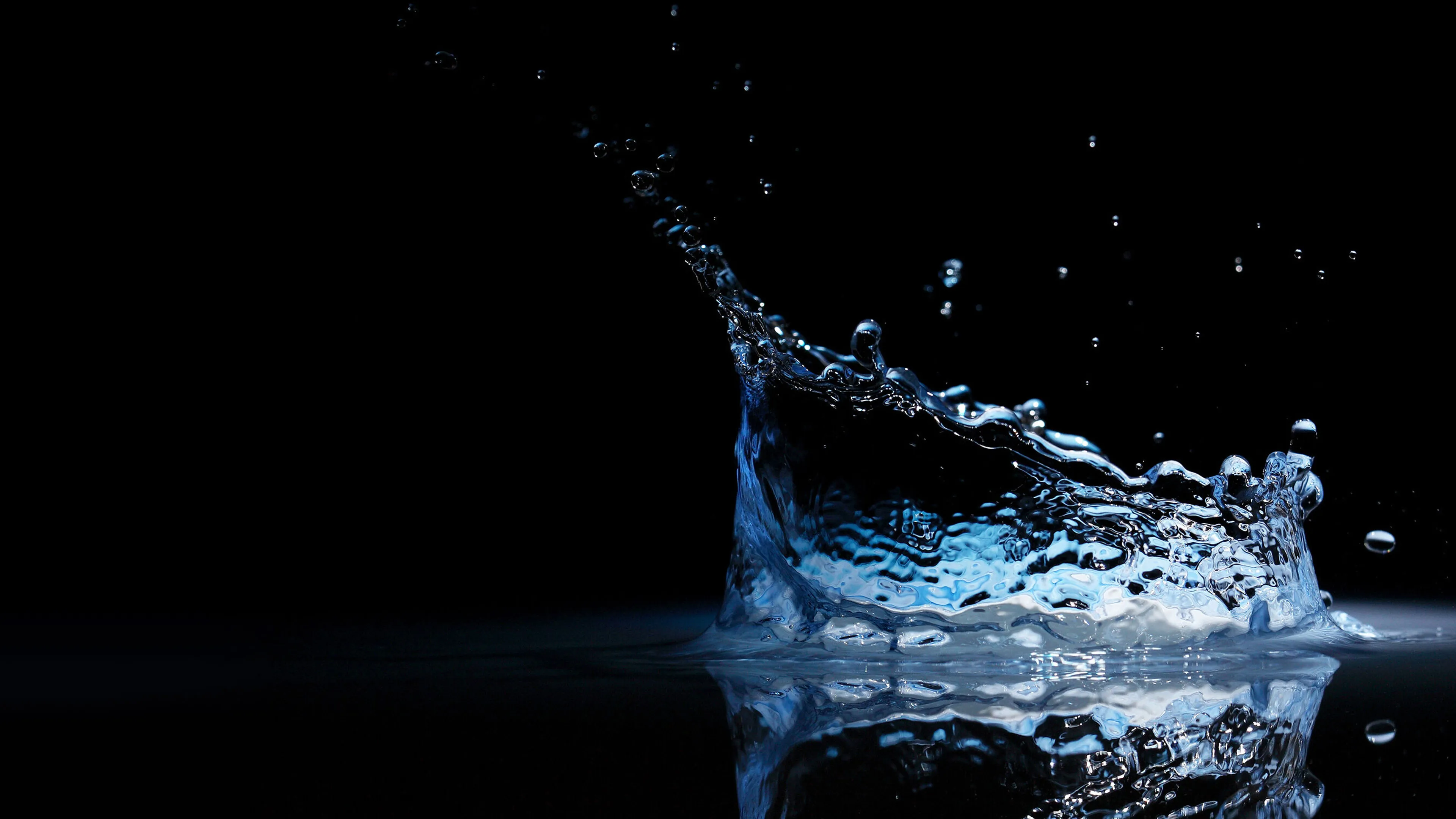 Splash of water droplets against a dark background, creating a dynamic and captivating visual effect.