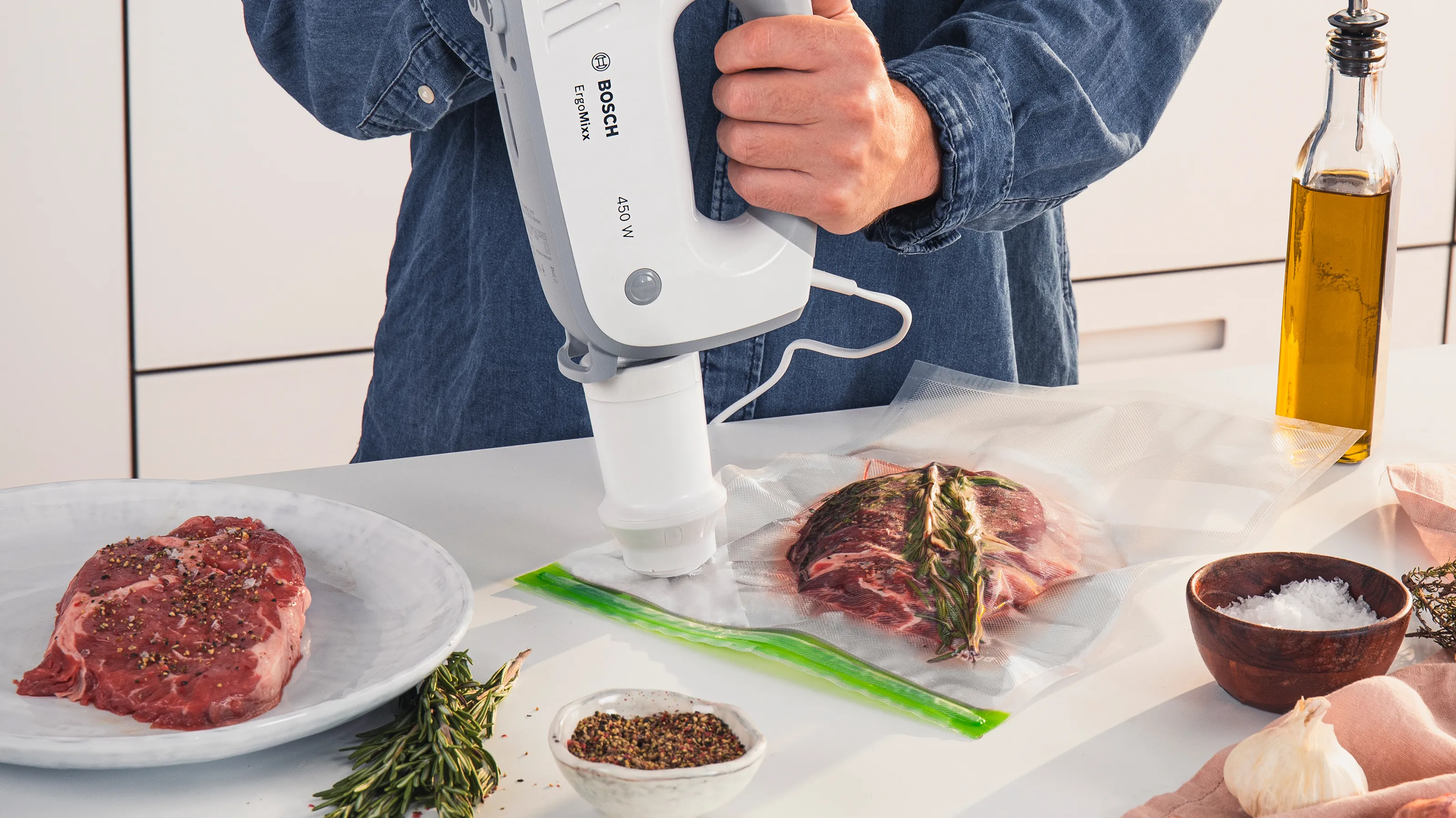 Une personne raccorde un batteur compatible à la valve d'un sac sous vide.